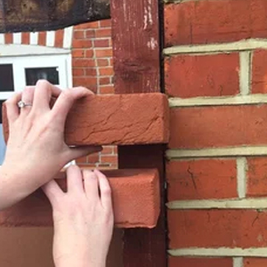 checking bricks against a wall to find a brick match
