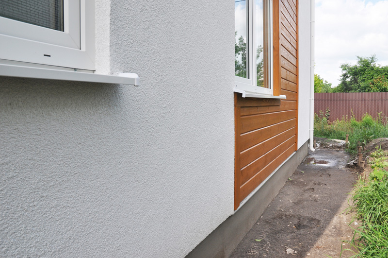 A house with painted exterior walls and a section of timber cladding.