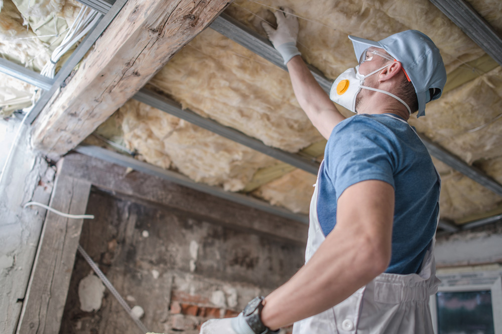 a contractor assessing the condition of loft insulation in a property